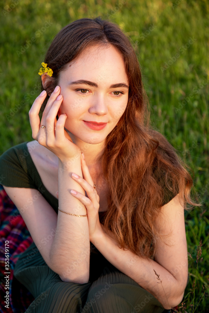 Portrait of a young smiling woman in the field.
