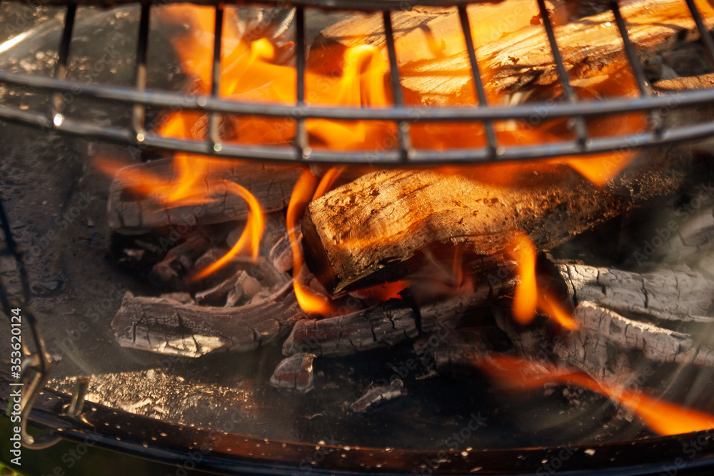 Fire and embers on the grill. Natural background of fire and burning wood.
