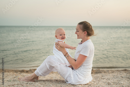 Cuadro en lienzo Young mother playing with baby on beach