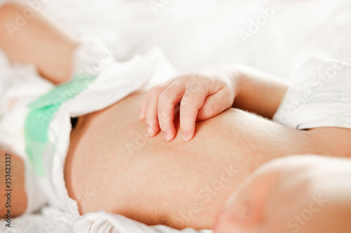 hand of infant on him chest