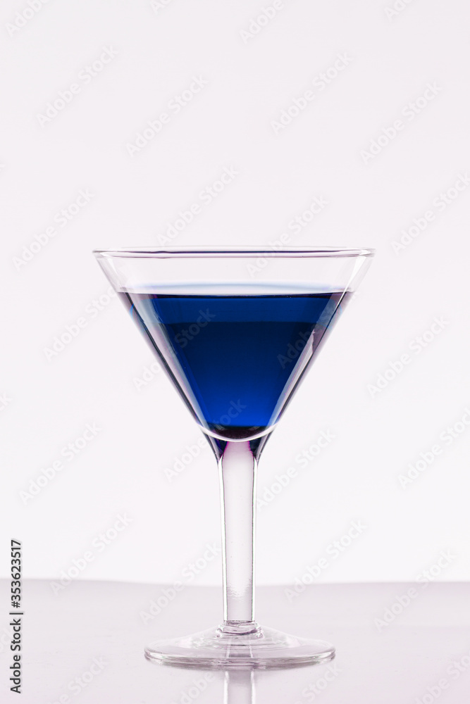 Glass of blue martini on a white background