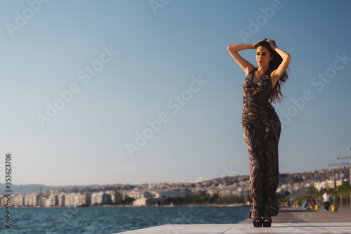 Girl in a long dress on the background of the promenade