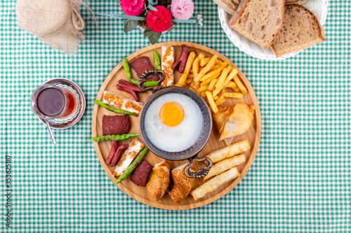 traditional Turkish hot breakfast plate; sausage, smoked pastry, halloumi cheese, egg with tea