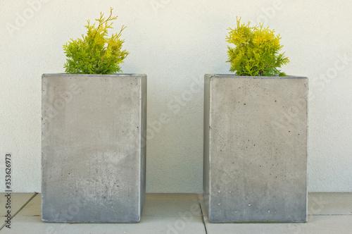 Modern concrete flower pots on front porch of a house