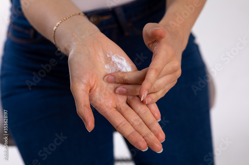 Woman applying hand cream to moisturize skin - stock photo