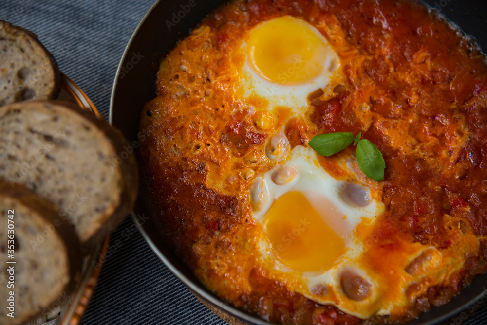 Shakshouka - eggs in tomato sauce, served in a frying pan Shakshouka - eggs in tomato sauce, served in a frying pan