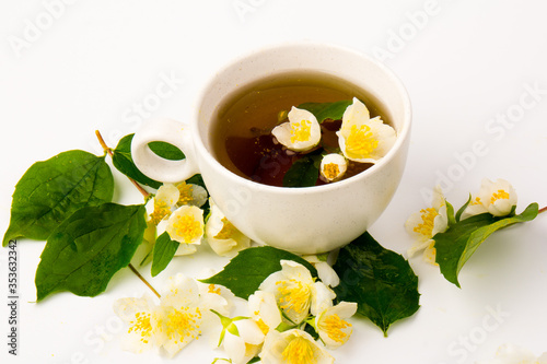 Jasmine flowers whith cup of tea on white background. Space for text
