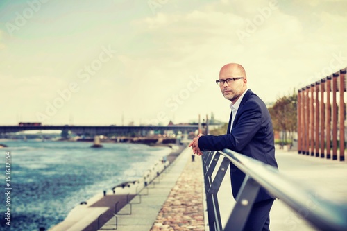 Portrait of thoughtful mature businessman leaning on railing  © moodboard