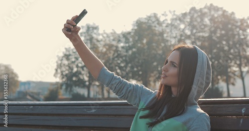 beautiful young hipster stylish woman selfie in park