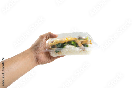Fotografi Hand holding Stir-fried kale vegetable with crispy pork in plastic box,thai lunch box,thai food packed lunch