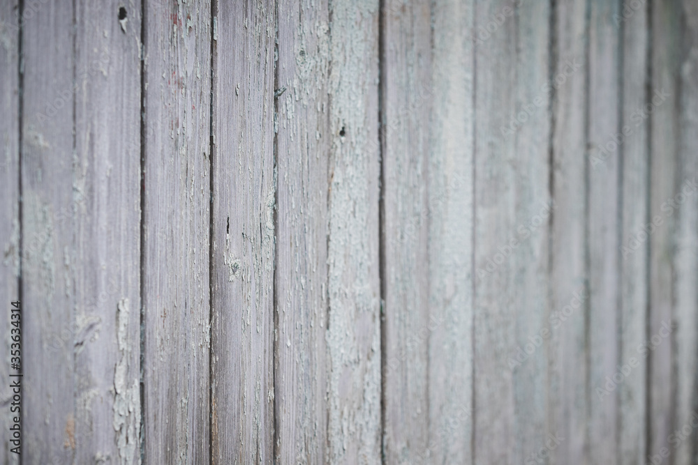 Closeup of an old texture of a weathered wooden wall painted in turquoise color. Aged wooden plank fence made of flat table boards. Copy space. Selective focus
