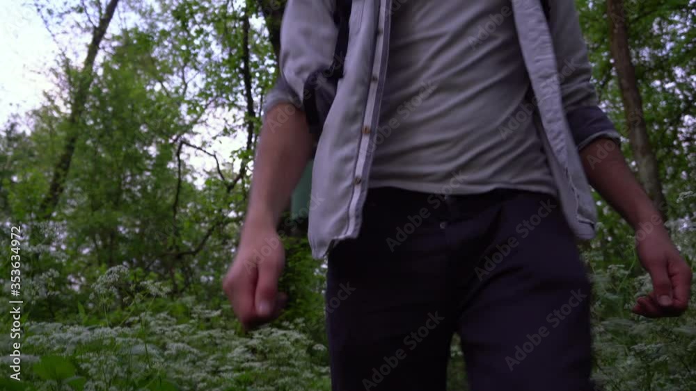 A young Caucasian man makes his way through the forest with a backpack. Soft focus nature concept. A young Caucasian man makes his way through the forest with a backpack. Soft focus nature concept.
