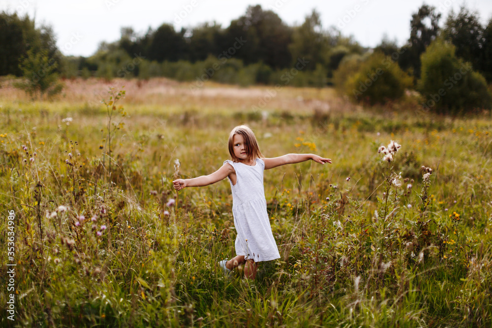Caucasian girl child runs across the field, happy free childhood Caucasian girl child runs across the field, happy free childhood