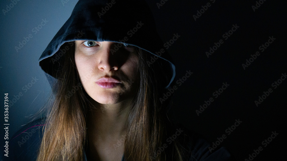Portrait of a woman with a hood in the dark. Portrait of a woman with a hood in the dark.