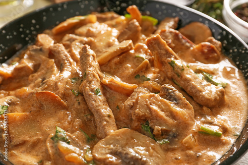 Tasty beef stroganoff in frying pan, closeup photo