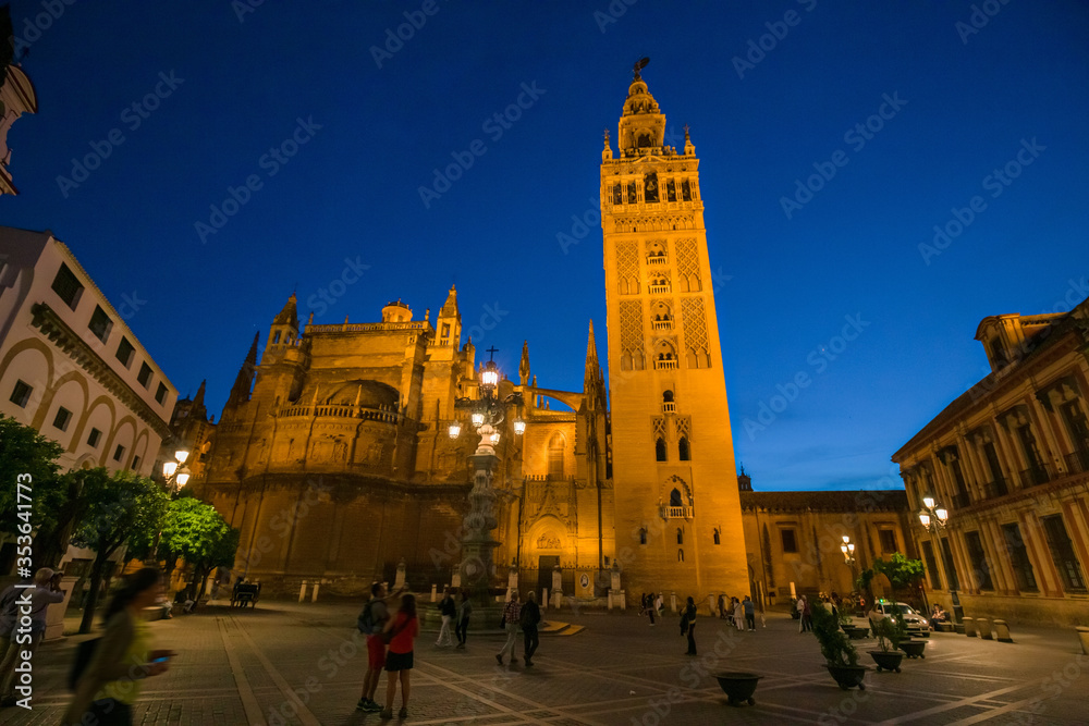 Naklejka premium Night view of the Plaza Virgen de los Reyes with the Giralda and the cathedral of Seville, Spain.