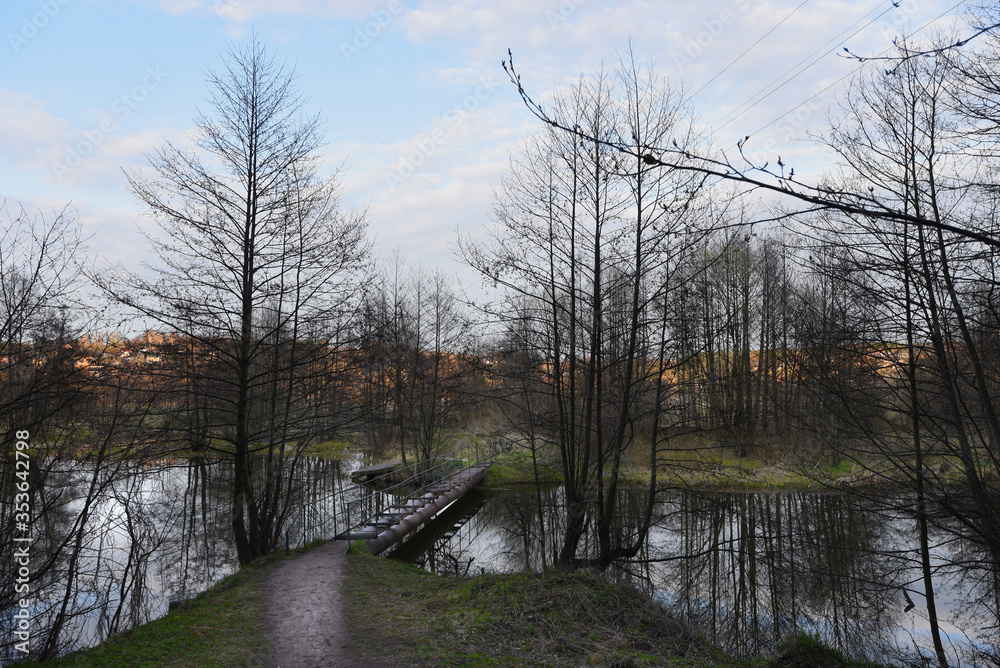 Walking bridge across a slim narrow river. Uptown Walking bridge across a slim narrow river. Uptown