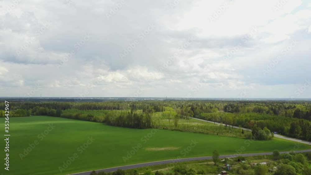 Green field and cloudy sky with a green forest on the horizon. Green field and cloudy sky with a green forest on the horizon.
