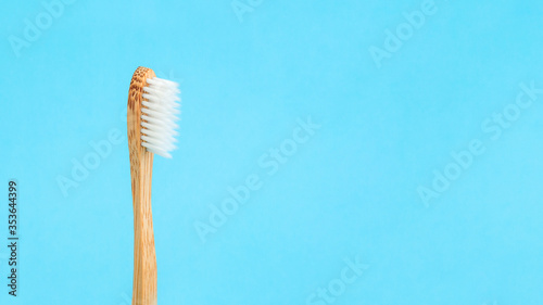 Close-up of bamboo toothbrush on the blue banner with copy space. Caring for oral health and personal hygiene.