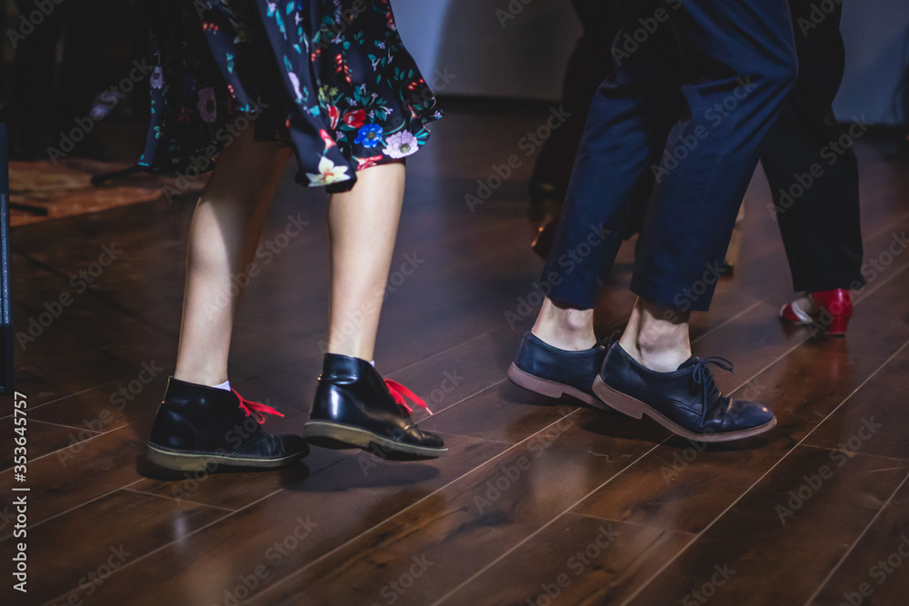 Dancing shoes of young couple dance retro jazz swing dances on a ballroom club wooden floor, close up view of shoes, female and male, dance lessons Dancing shoes of young couple dance retro jazz swing dances on a ballroom club wooden floor, close up view of shoes, female and male, dance lessons