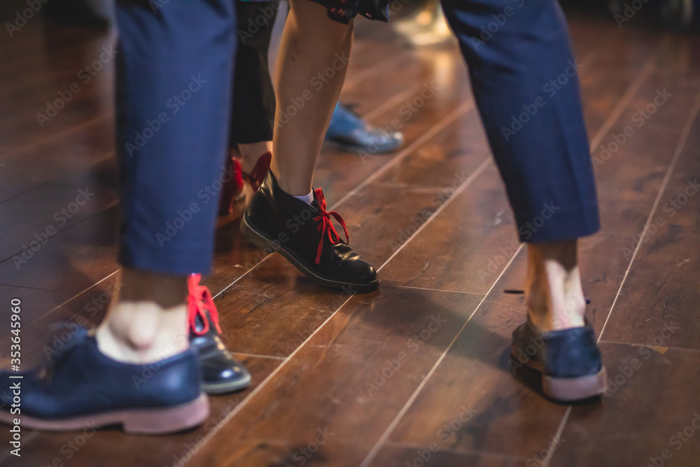 Dancing shoes of young couple dance retro jazz swing dances on a ballroom club wooden floor, close up view of shoes, female and male, dance lessons