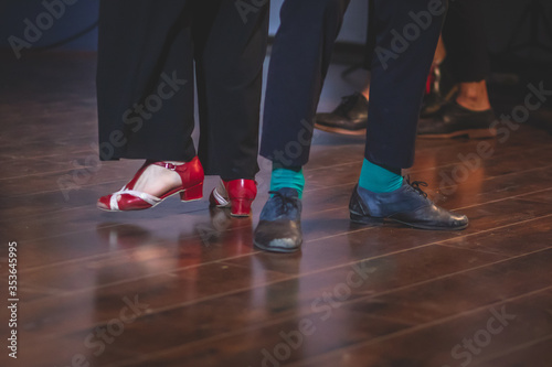 Dancing shoes of young couple dance retro jazz swing dances on a ballroom club wooden floor, close up view of shoes, female and male, dance lessons © tsuguliev