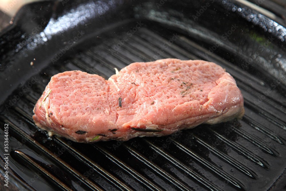 Grilling steak on a grill pan. Chef making steak. Beef tender steak on the grill pan. 