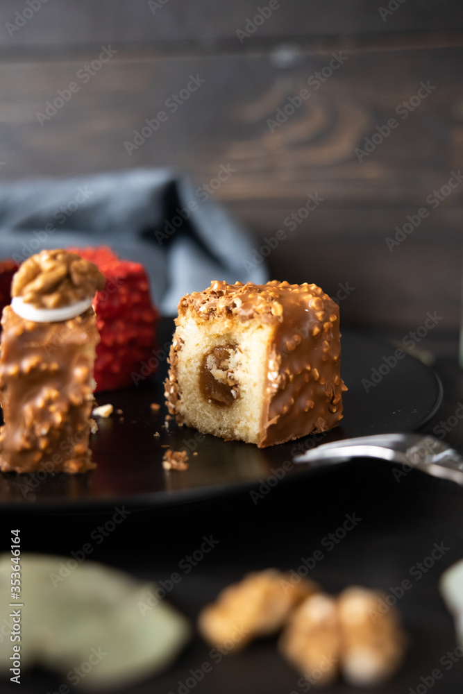 two red and chocolate cupcakes in a split on a black plate two red and chocolate cupcakes in a split on a black plate