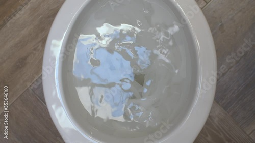 Close up clogging of the toilet. The water flows into the toilet but does not go away. Toilet paper causes clogging. Plumbing in need of repair. Top view