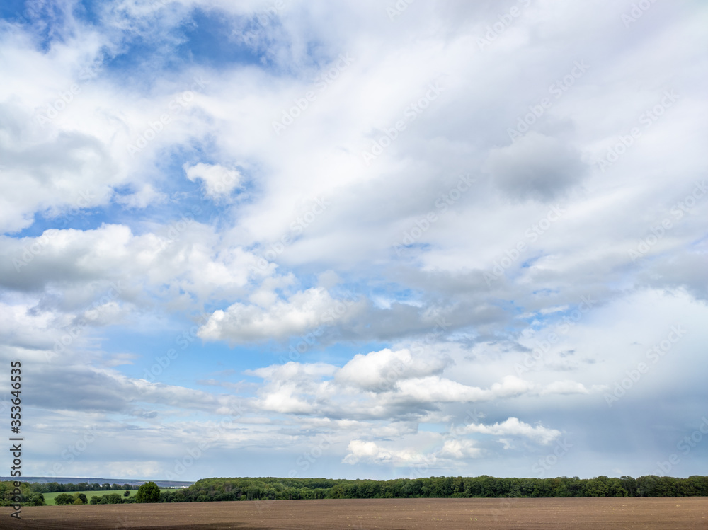 Beautiful sky with high white clouds, blue cloudscape moody sky in rural spring countryside Beautiful sky with high white clouds, blue cloudscape moody sky in rural spring countryside