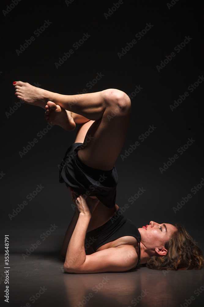 Young girl doing yoga on a black background Young girl doing yoga on a black background