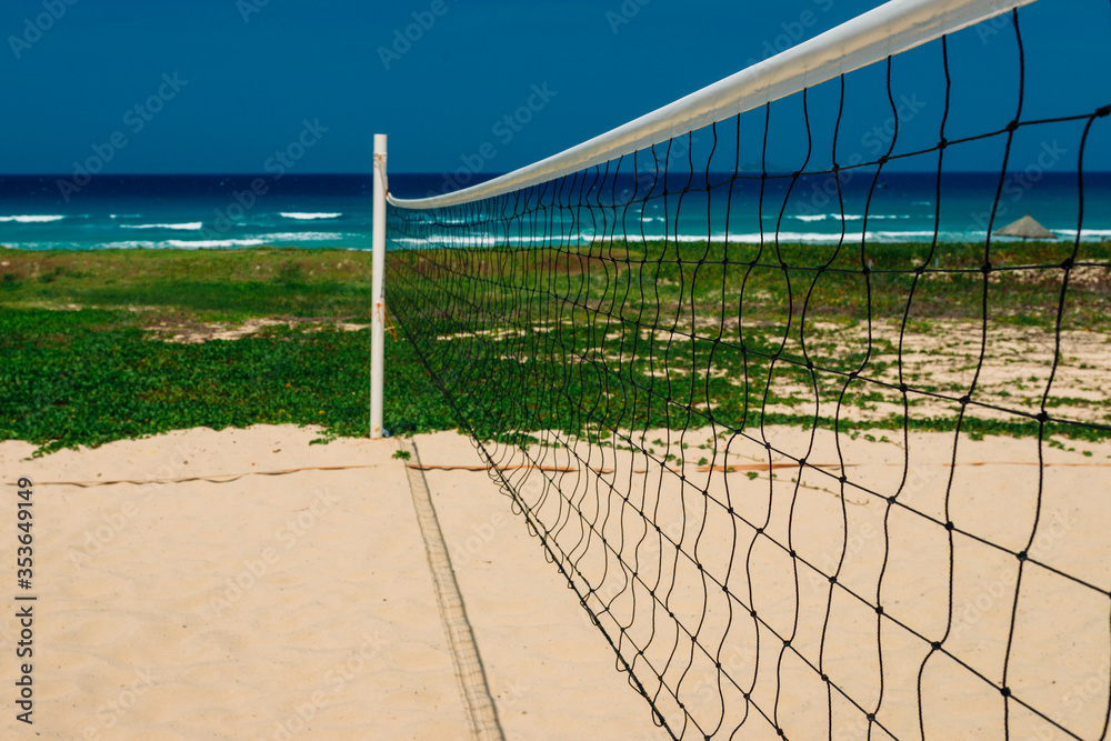 Beach volleyball court on the sandy shore near the sea. No one at the site. Sea view, sunny day Beach volleyball court on the sandy shore near the sea. No one at the site. Sea view, sunny day