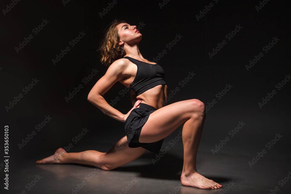 Young girl doing yoga on a black background