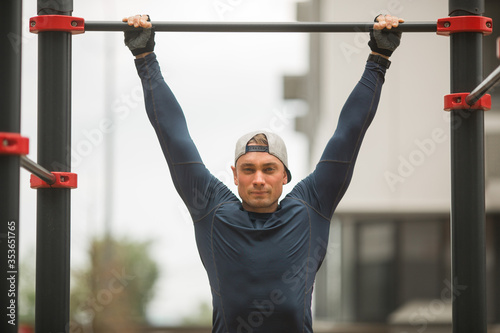 handsome young man in sportswear is training outdoors © Alexandr