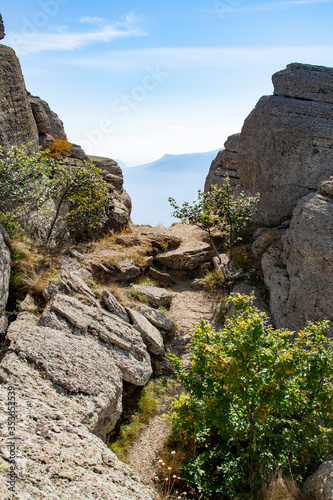 Canvas Print Mountain trail among the rocks against the backdrop of mountains and blue sky