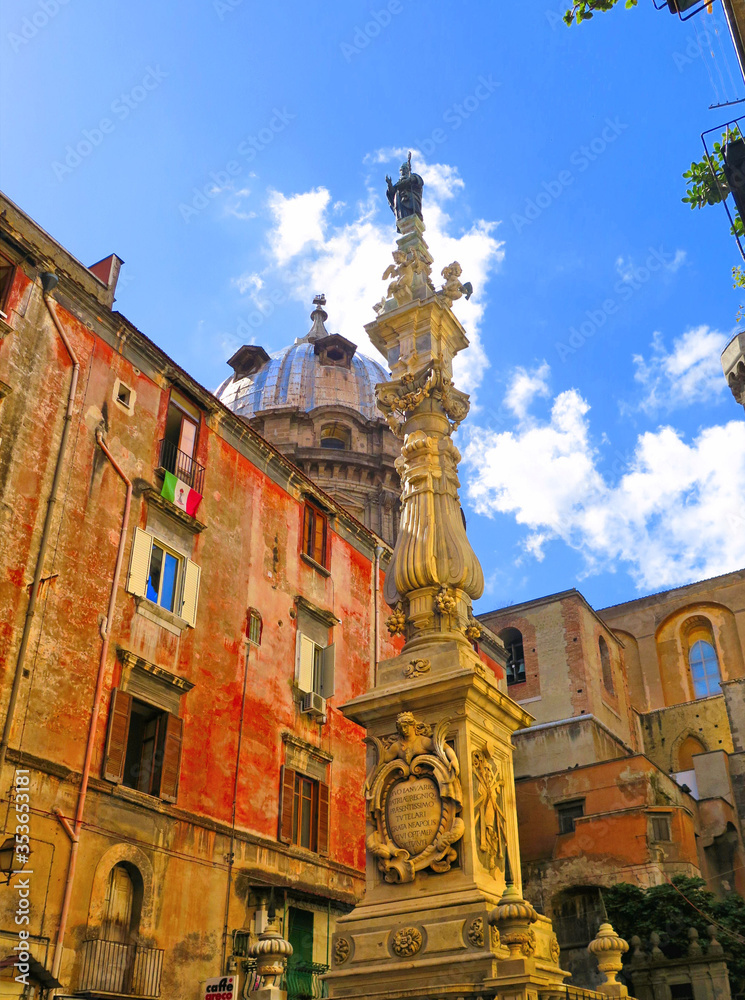 Obraz premium Napoli, Piazza Riario Sforza square, Obelisk of San Gennaro column and old buildings and dome in background. Naples Italy 