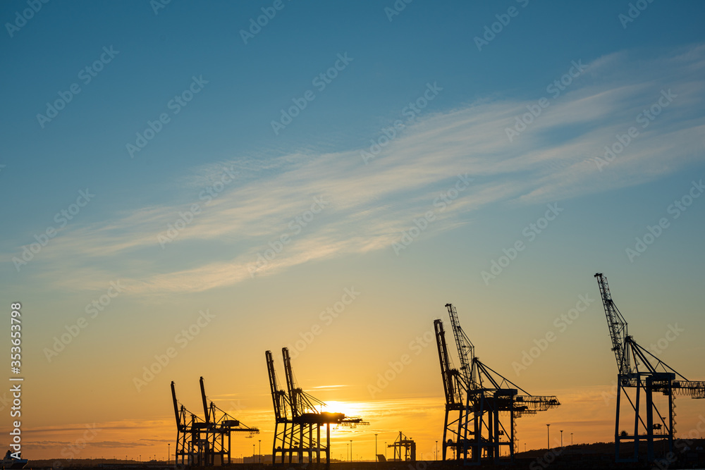 Ship to shore container cranes at sunset