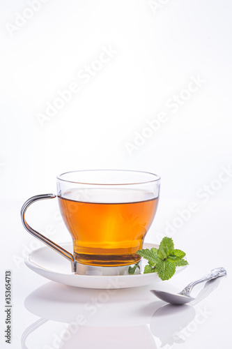 Infusion of peppermint in crystal glass and fresh mint leaves, isolated on white background.