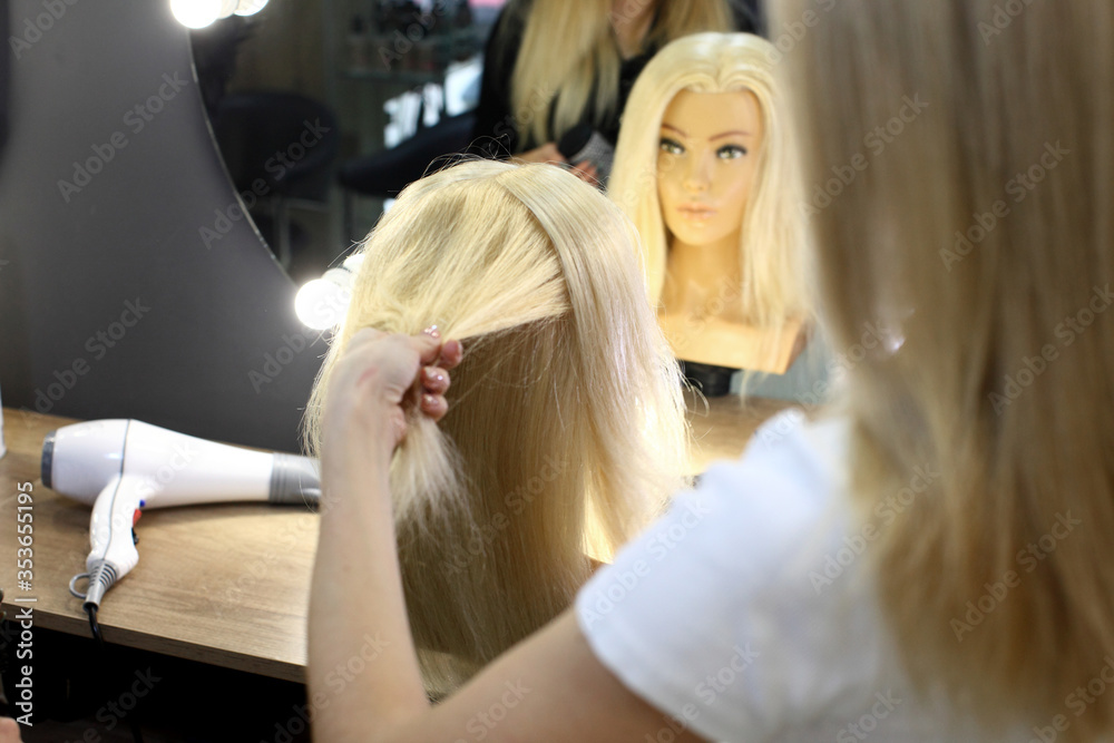 Creating hairstyles on a mannequin. Training hair styling on a mannequin. Creating hairstyles on a mannequin. Training hair styling on a mannequin.