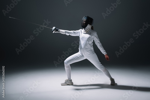 Fencer training with rapier on white surface on black background