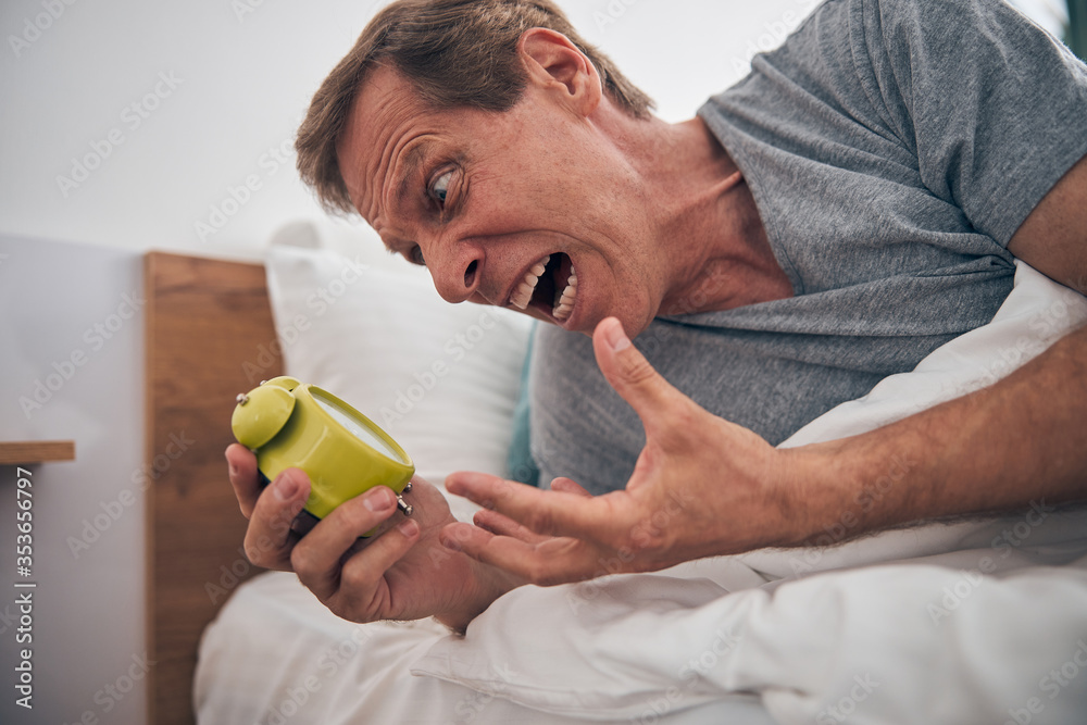 Emotional man demonstrating his hate to early awakening Emotional man demonstrating his hate to early awakening