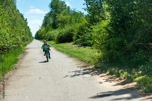 Boy on bicycle at summer asphalt road. Kid cycling outdoors. Summer sport activity concept. Soft focus © thayra83