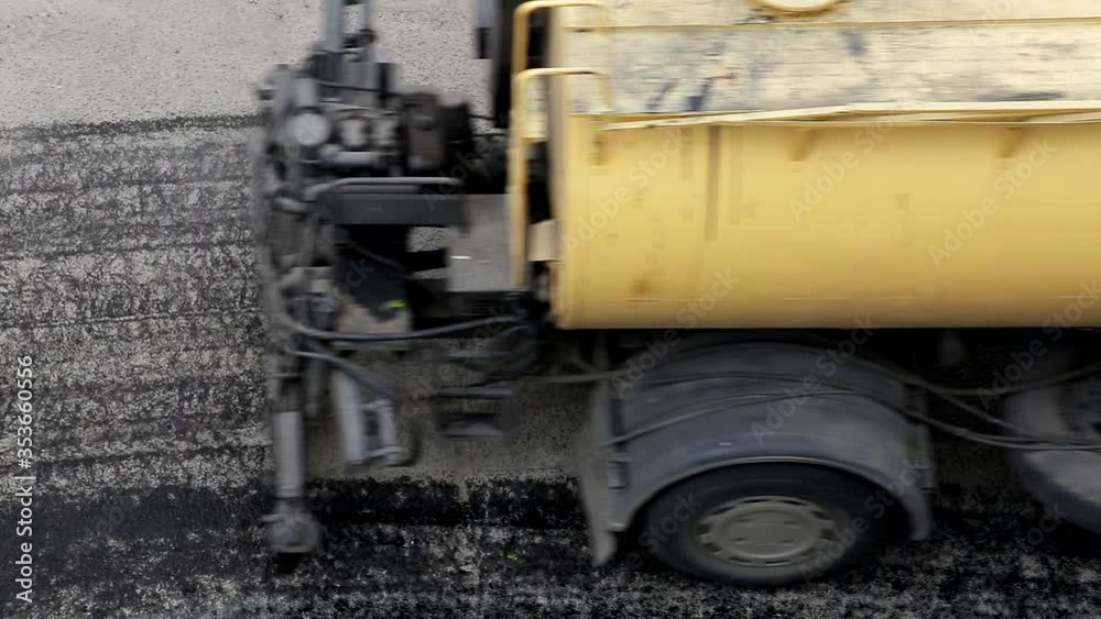 Special equipment spills old asphalt with bitumen for better bonding of a new asphalt layer, road repair, industry Special equipment spills old asphalt with bitumen for better bonding of a new asphalt layer, road repair, industry