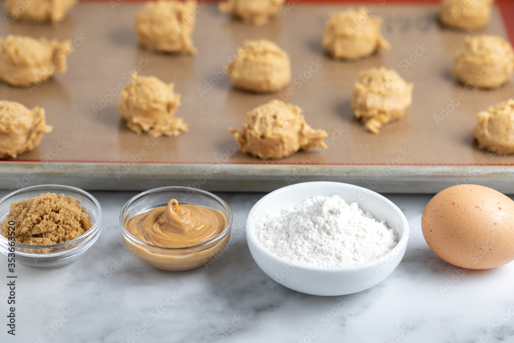 Peanut butter baking ingredients with cookie dough balls in the background Peanut butter baking ingredients with cookie dough balls in the background