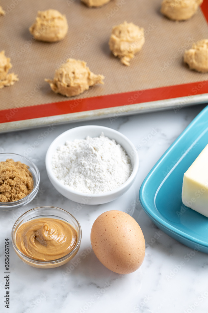 Baking ingredients with cookie dough ball in the background