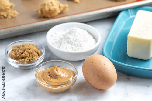 Peanut butter cookie baking ingredients with dough ball in the background