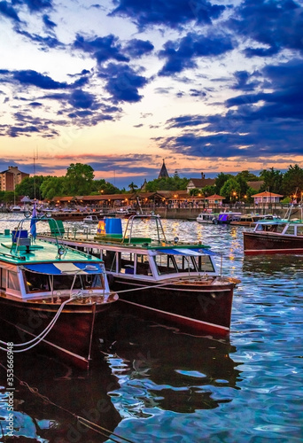 Fluvial station, with vintage wood boats, at twilight. With lights and buildings at the harbor. Tigre, Buenos Aires