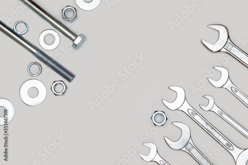 wrenches, bolt, nut and washers on a gray concrete background. top view.