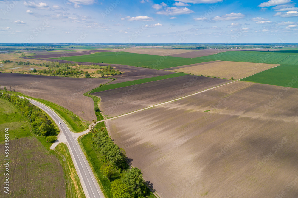 Rural landscape. Aerial view. View of highway and plowed and green fields in spring