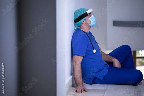 medico con cuffietta e mascherina  in camice blu isolato su sfondo photo